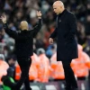 Liverpool manager Arne Slot appears dejected as Manchester City manager Pep Guardiola celebrates 