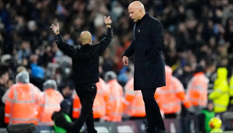 Liverpool manager Arne Slot appears dejected as Manchester City manager Pep Guardiola celebrates 