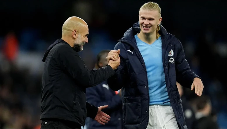 Manchester City manager Pep Guardiola speaks with Erling Haaland 