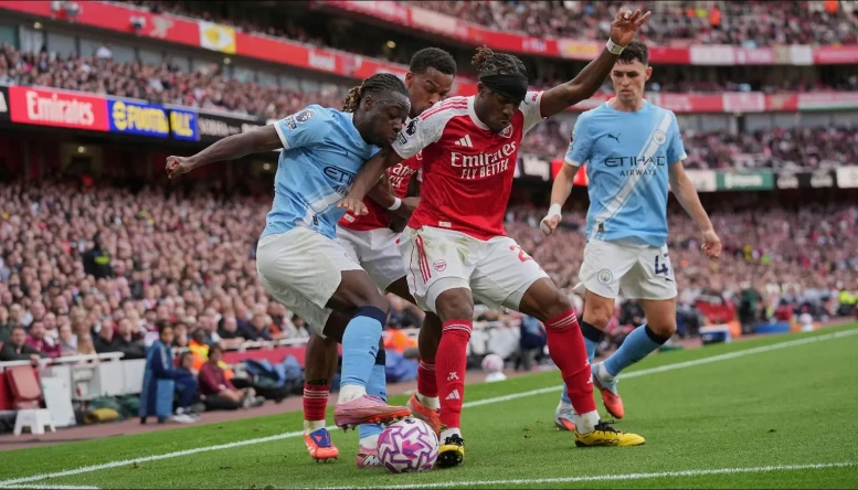Manchester City's Jeremy Doku and Arsenal's Noni Madueke fight for the ball