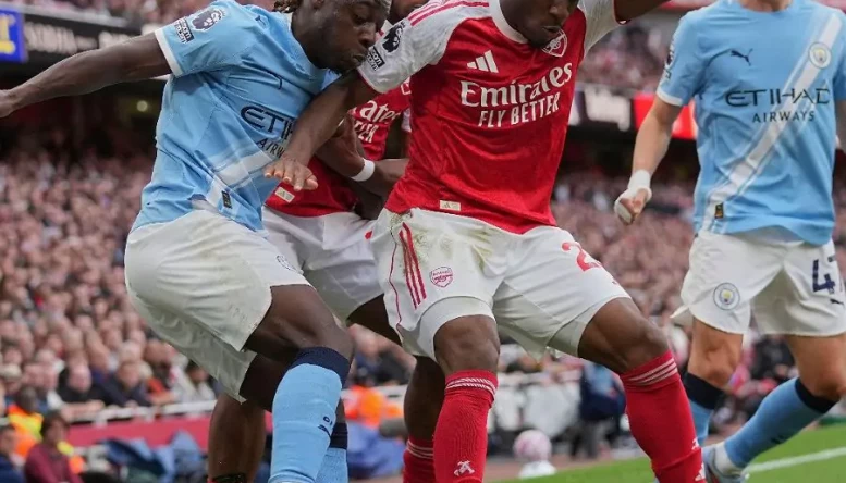Manchester City's Jeremy Doku and Arsenal's Noni Madueke fight for the ball